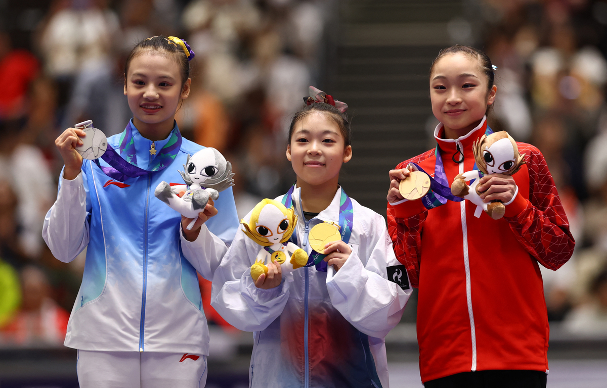 황서현(가운데)이 지난 25일 일본 나고야 종합체육관에서 열린 2026 아이치·나고야 아시안게임 기계체조 여자 평균대에서 금메달을 딴 뒤 은메달리스트 추치위안(중국·왼쪽), 동메달리스트 오카무라 마나(일본)와 시상대에서 기뻐하고 있다. 로이터연합뉴스